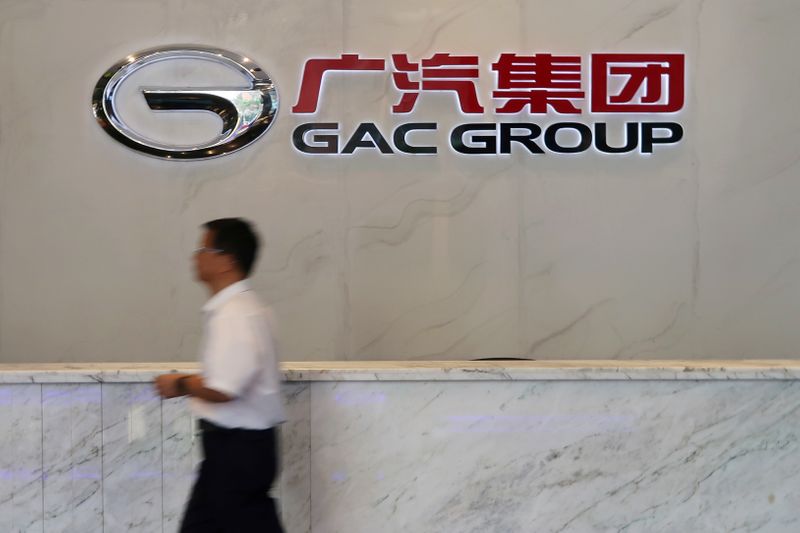 &copy; Reuters. Man walks past the logo of Chinese automobile maker GAC Group at the company headquarters in Guangzhou