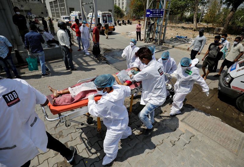 &copy; Reuters. FOTO DE ARCHIVO: Un paciente con problemas respiratorios es trasladado en silla de ruedas en Ahmedabad, India