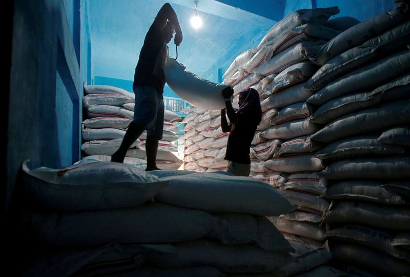 &copy; Reuters. Foto de archivo. Trabajadores trasladan sacos de azúcar en una bodega en Calcuta