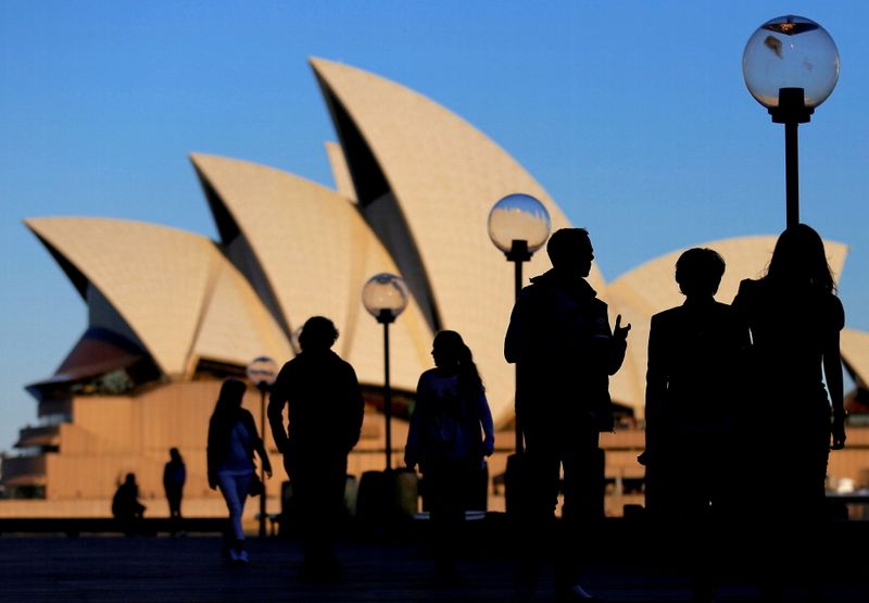 © Reuters. FILE PHOTO: People are silhouetted against the Sydney Opera House at sunset in Australia