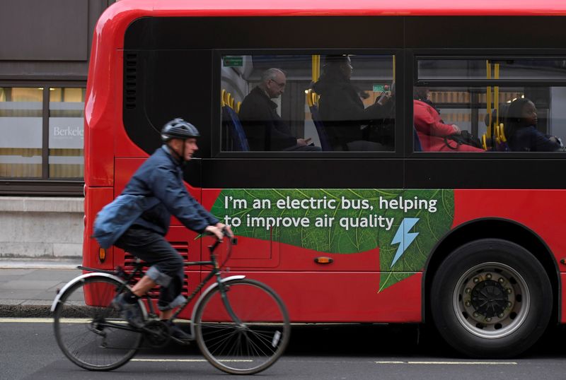 &copy; Reuters. FILE PHOTO: A cyclist rides past an electric public bus on the day that Mayor of London Sadiq Khan outlined plans to place a levy on the most polluting vehicles in London, Britain