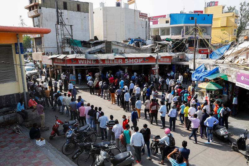 &copy; Reuters. Pessoas fazem fila em frente a loja de bebidas em Nova Délhi depois de governo local decretar seis dias de lockdown para frear disseminação do coronavírus