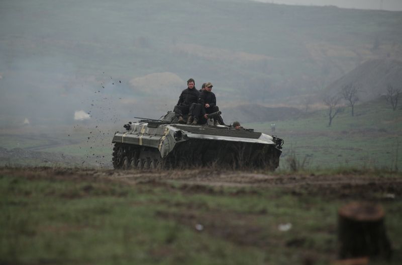 &copy; Reuters. Los miembros del servicio de las fuerzas armadas de Ucrania conducen un vehículo blindado durante un entrenamiento en un campo de tiro en la región de Donetsk