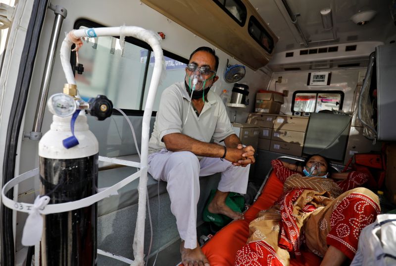 &copy; Reuters. Patients with breathing problem wait inside an ambulance to enter a COVID-19 hospital for treatment, in Ahmedabad