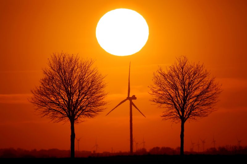 © Reuters. FILE PHOTO: Power-generating windmill turbines are seen during sunset in Bourlon