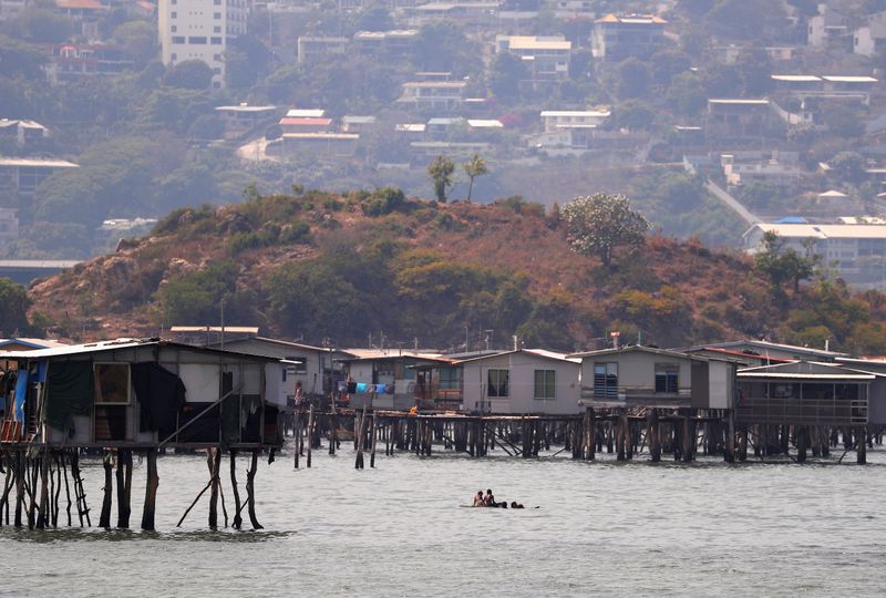 &copy; Reuters. FILE PHOTO: Newly constructed apartment blocks are seen behind the stilt house village called Hanuabada, located in Port Moresby Harbour in Papua New Guinea