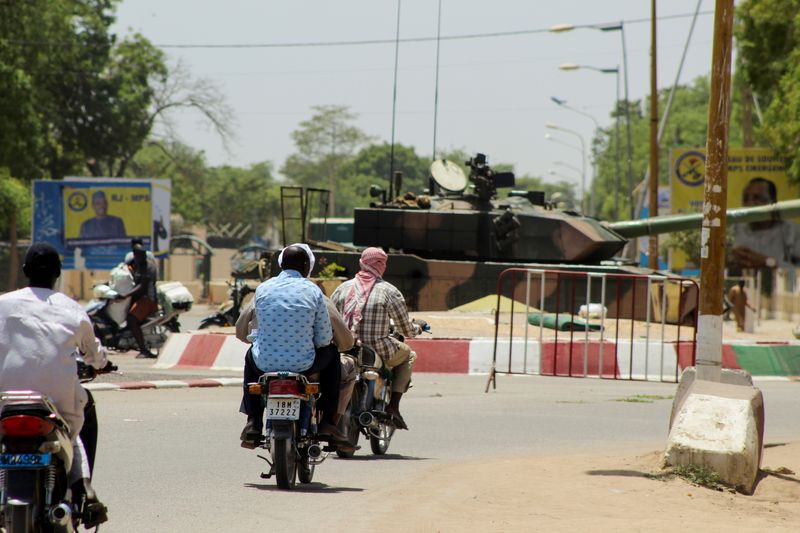 &copy; Reuters. People drive past a Chad army tank near the presidential palace, in N&apos;djamena
