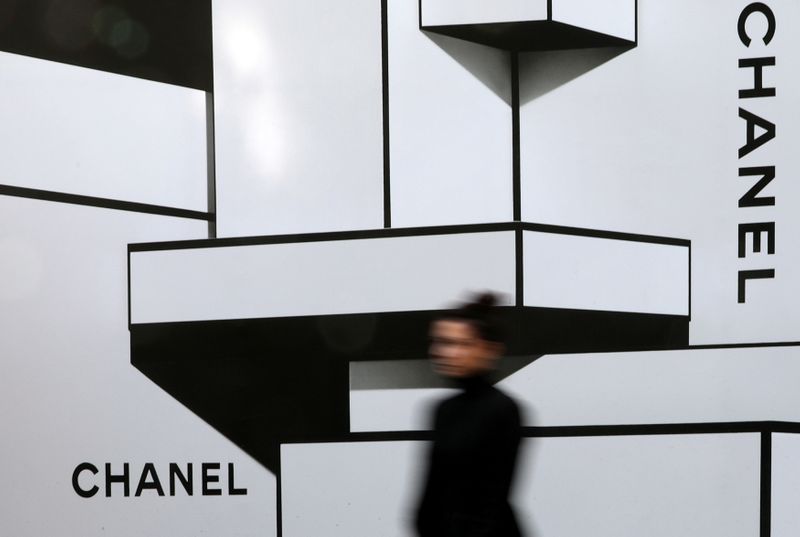 &copy; Reuters. FILE PHOTO: A woman walks past the logos of French luxury goods maker Chanel in Nice