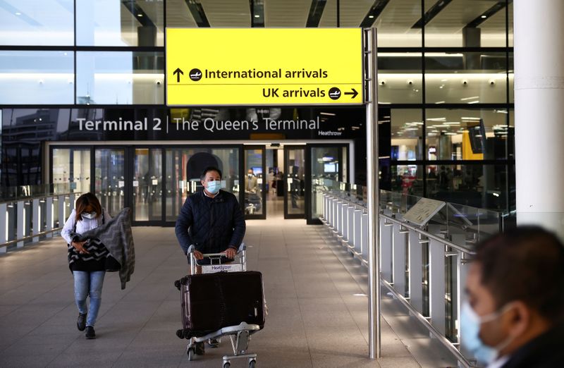 &copy; Reuters. FILE PHOTO: Travellers walk through Terminal 2 at Heathrow Airport, amid the coronavirus disease (COVID-19) outbreak in London