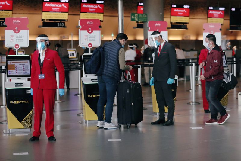 &copy; Reuters. Foto de archivo.  Trabajadores con caretas y máscaras protectoras por la pandemia del COVID-19 se alistan para registrarse en el Aeropuerto Internacional El Dorado de Bogotá