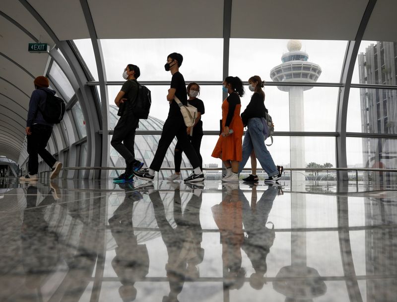 &copy; Reuters. People pass the control tower of Singapore&apos;s Changi Airport