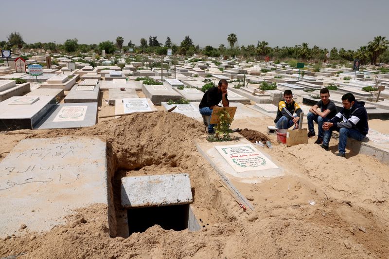 &copy; Reuters. Palestinians wait to bury the body of their relative, who died after contracting COVID-19, at a cemetery, east of Gaza City