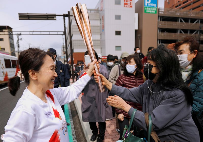 &copy; Reuters. Imagen de archivo de espectadores intentando tocar la antorcha que llega Junko Ito, después de su tramo durante el relevo de la antorcha de los Juegos Olímpicos Tokio 2020 en el segudo día de su recorrido en Fukushima