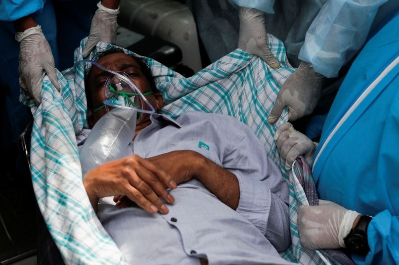 © Reuters. A patient suffering from the coronavirus disease (COVID-19) is evacuated from a hospital after it caught fire in Virar, on the outskirts of Mumbai