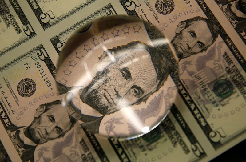 &copy; Reuters. FILE PHOTO: FILE PHOTO: Sheets of Lincoln five dollar bill are seen through magnifying glass at  Bureau of Engraving and Printing in Washington