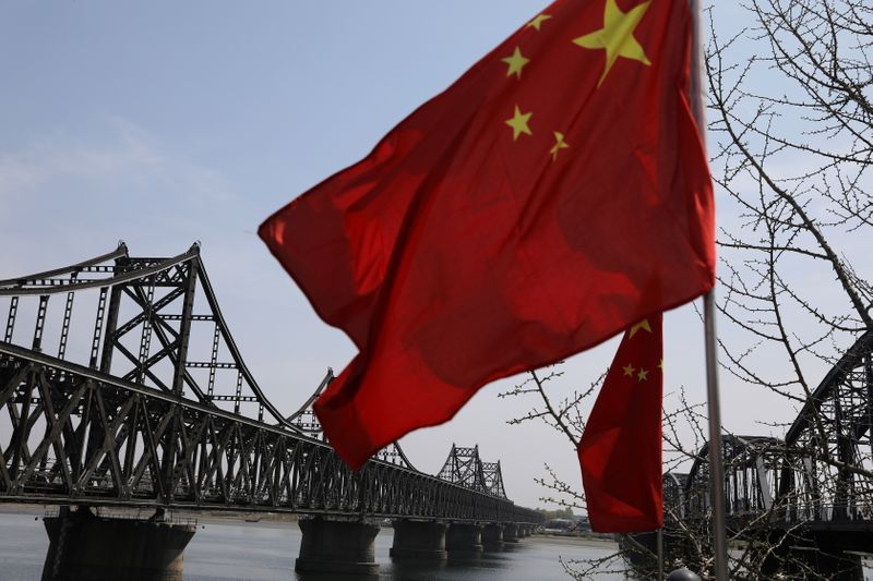&copy; Reuters. Chinese national flag flutters near the Friendship Bridge and Broken Bridge over the Yalu River, in Dandong