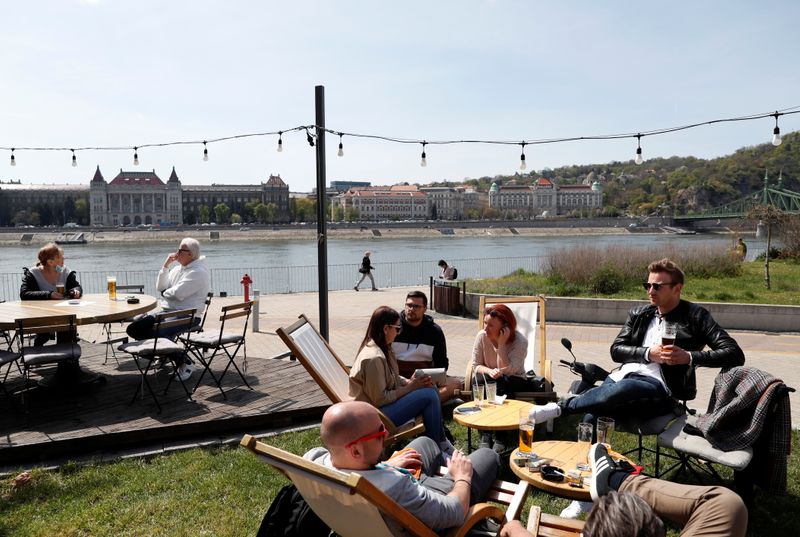 &copy; Reuters. Guests enjoy the sunny weather as they sit in front of a restaurant after the Hungarian government allowed to reopen outdoor terraces in Budapest