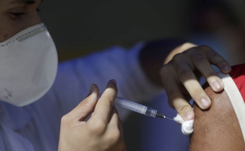 &copy; Reuters. Profissional de saúde aplica vacina contra Covid-19 em Duque de Caxias, no Rio de Janeiro