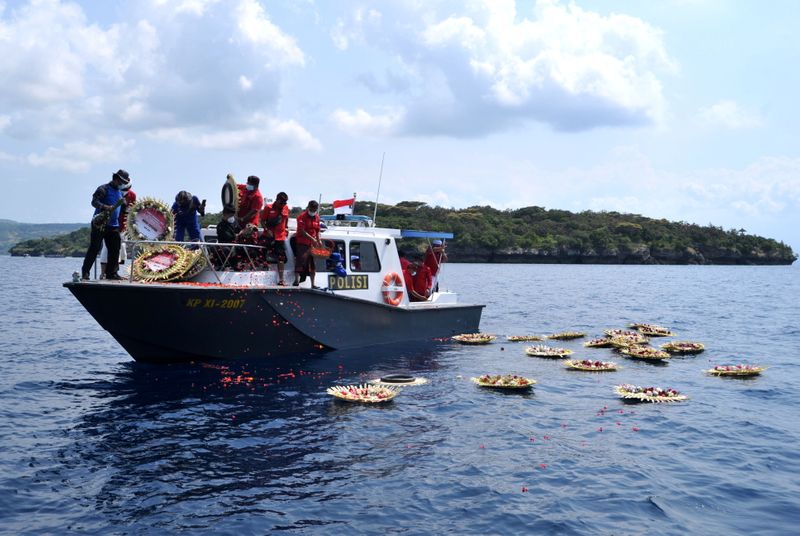 &copy; Reuters. Pessoas jogam pétalas de flores com nomes dos marinheiros que morreram em submarino no litoral da Indonésia