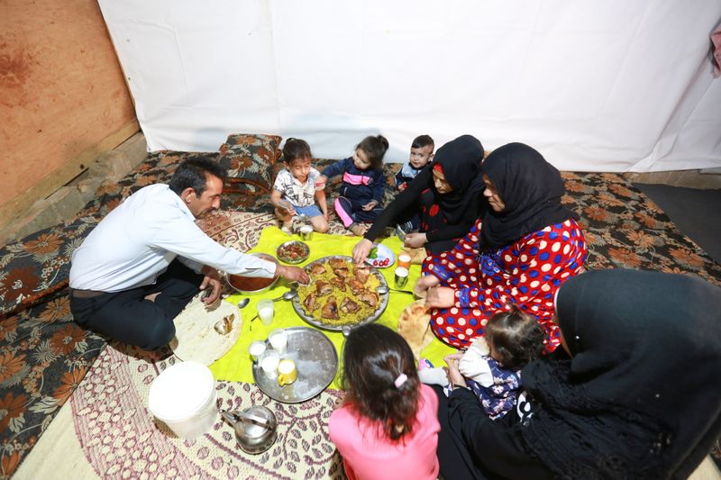 &copy; Reuters. Hussein al-Khaled and his family eat their Iftar (breaking fast) meal during the holy month of Ramadan inside a tent at an informal tented settlement in Bar Elias