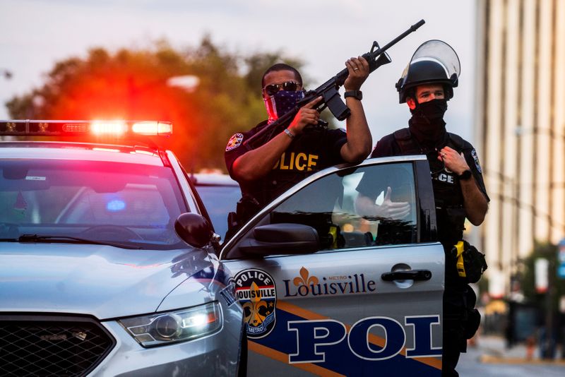 &copy; Reuters. FILE PHOTO: Louisville Police officers stand guard as demonstrators march during a peaceful protest after a grand jury decided not to bring homicide charges against police officers involved in the fatal shooting of Breonna Taylor, in Louisville