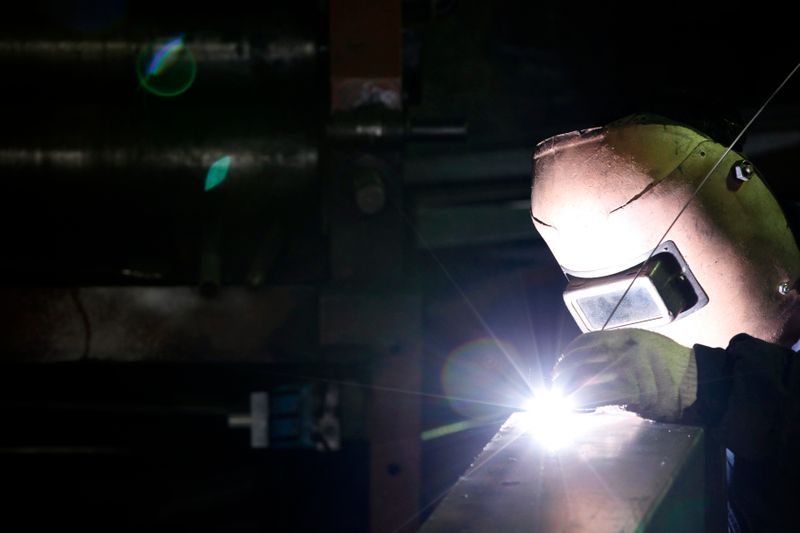 &copy; Reuters. FILE PHOTO: A worker welds iron at his steel product shop in Seoul