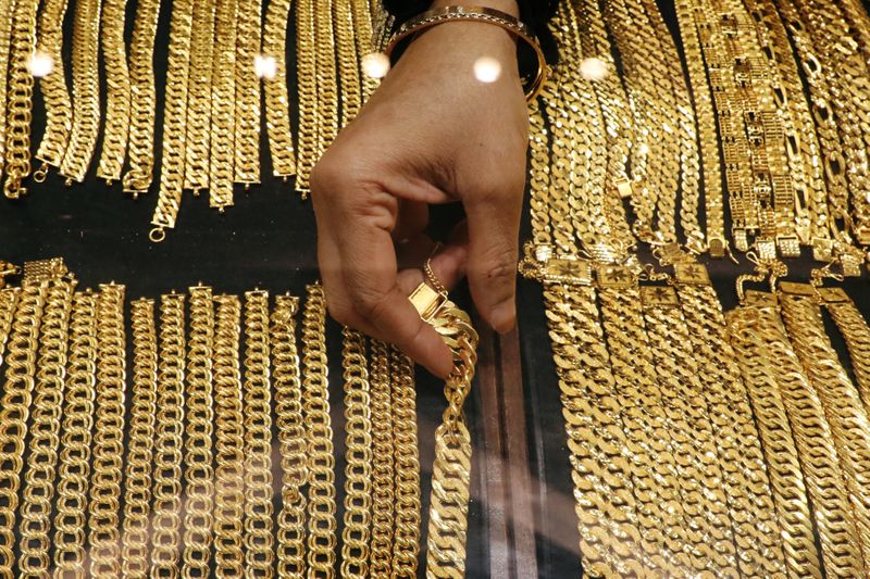 &copy; Reuters. A vendor arranges gold chains displayed at VJ Gold and Diamond jewellery shop in Kuala Lumpur
