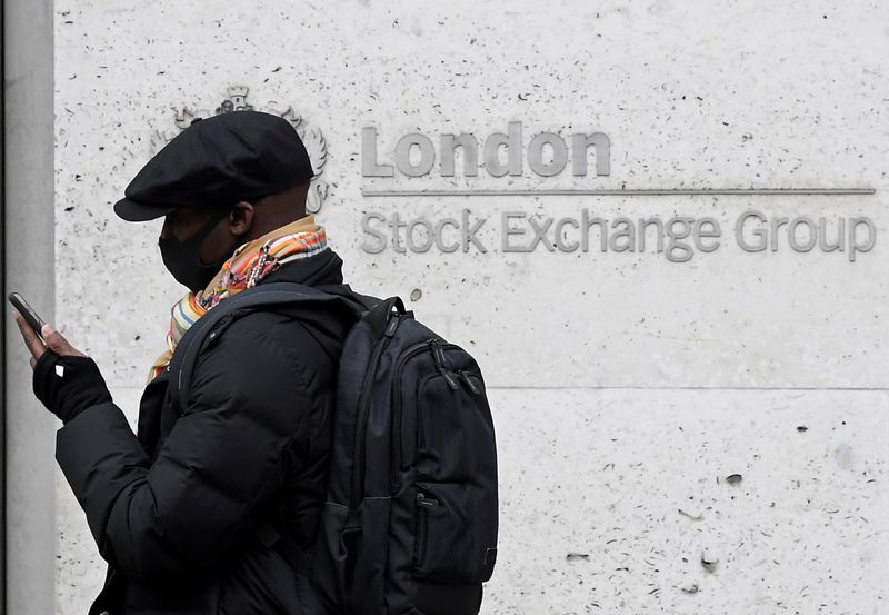 © Reuters. FILE PHOTO: A man wearing a protective face mask walks past the London Stock Exchange Group building in the City of London financial district, whilst British stocks tumble as investors fear that the coronavirus outbreak could stall the global economy, in L