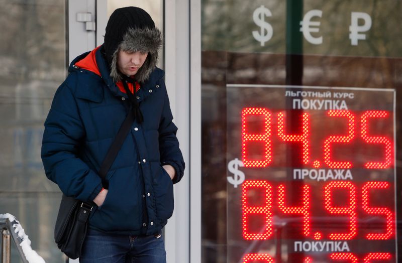 &copy; Reuters. A man walks near a board showing currency exchange rates of the U.S. dollar against the rouble in Moscow