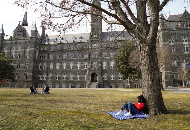 © Reuters. Georgetown University students take advantage of the warm sunshine in Washington