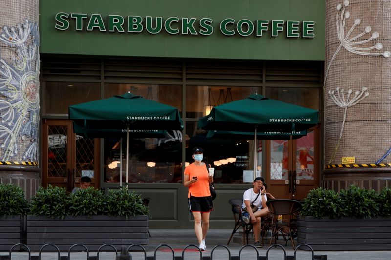 &copy; Reuters. FILE PHOTO: A woman leaves a cafe of Starbucks Coffee in Beijing