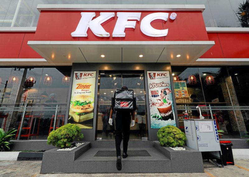 &copy; Reuters. FILE PHOTO: A delivery staff member wearing a protective mask enters a KFC fast food outlet after a delivery in Colombo