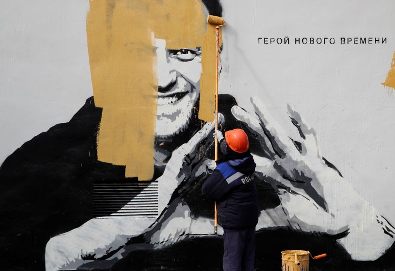 &copy; Reuters. A worker paints over a graffiti depicting Alexei Navalny in Saint Petersburg