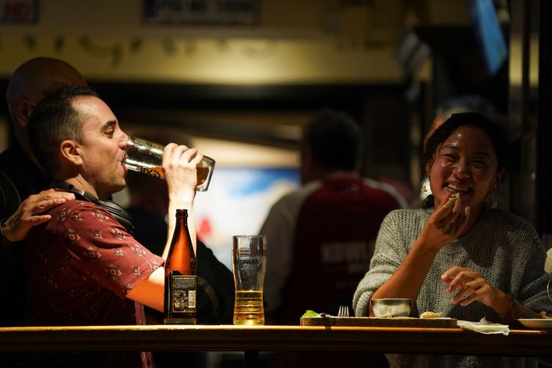 &copy; Reuters. People drink at a bar in Hong Kong&apos;s Lan Kwai Fong before bars, nightclubs and other entertainment venues are set to close