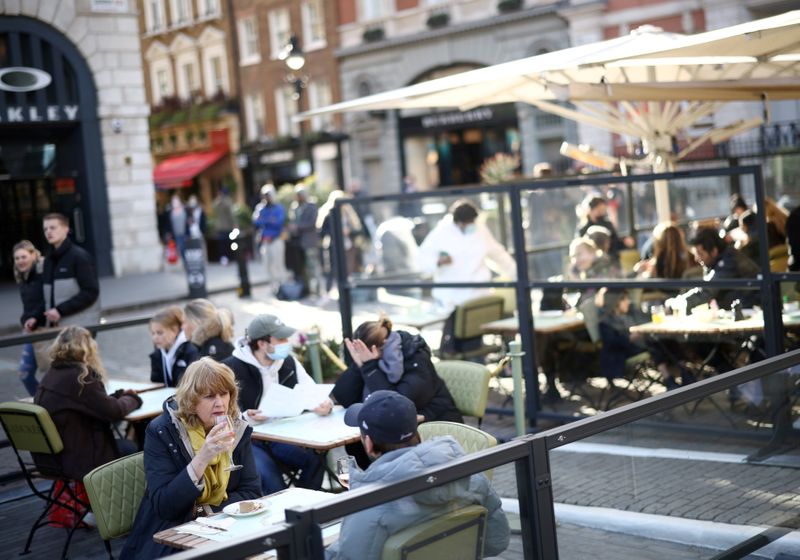 &copy; Reuters. FILE PHOTO: People sit at an outside restaurant area, as the coronavirus disease (COVID-19) restrictions ease, at Covent Garden in London,