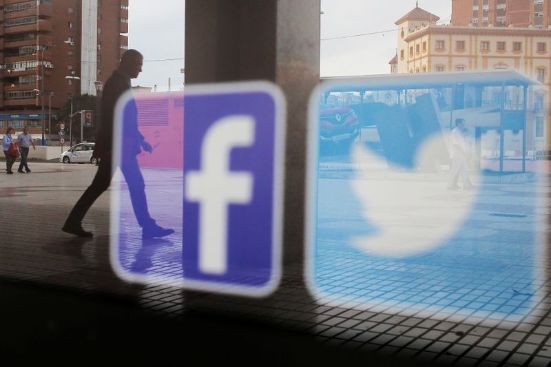 &copy; Reuters. FILE PHOTO: Facebook and Twitter logos are seen on a shop window in Malaga