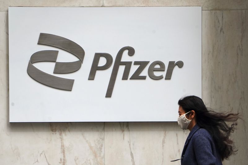 &copy; Reuters. A person walks past a Pfizer logo in New York City