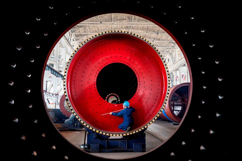 &copy; Reuters. An employee measures a newly manufactured ball mill machine at a factory in Nantong, Jiangsu