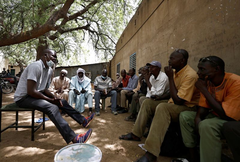 &copy; Reuters. Men sit in shade outside CLTT office in N&apos;djamena