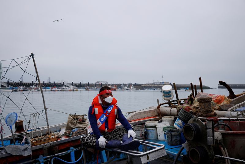&copy; Reuters. A South Korean fisherman sits on his boat during a marine protest, part of nationwide protests to demand Japan withdraw its decision to release contaminated water from its crippled Fukushima nuclear plant into the sea, at the sea off Incheon