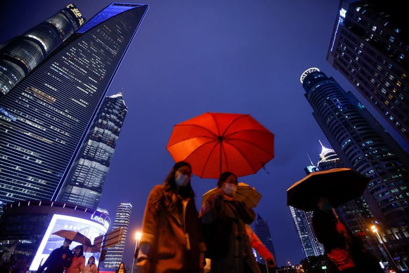 &copy; Reuters. People walk with umbrellas in Lujiazui financial district in Pudong, Shanghai