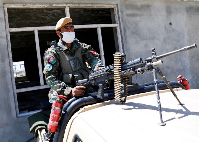 © Reuters. FILE PHOTO: An Afghan National Army soldier sits on a back of an army vehicle at a checkpoint on the outskirts of Kabul