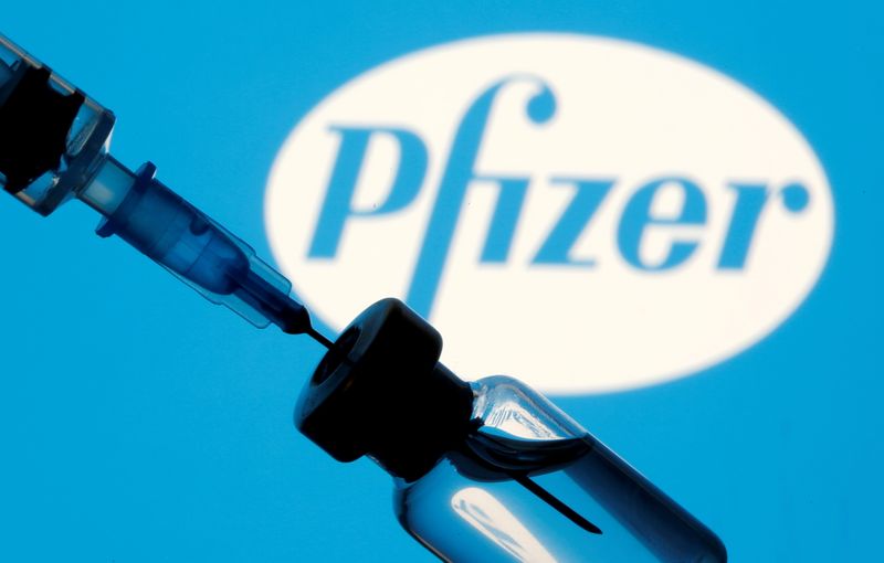 © Reuters. FILE PHOTO: Vial and sryinge are seen in front of displayed Pfizer logo