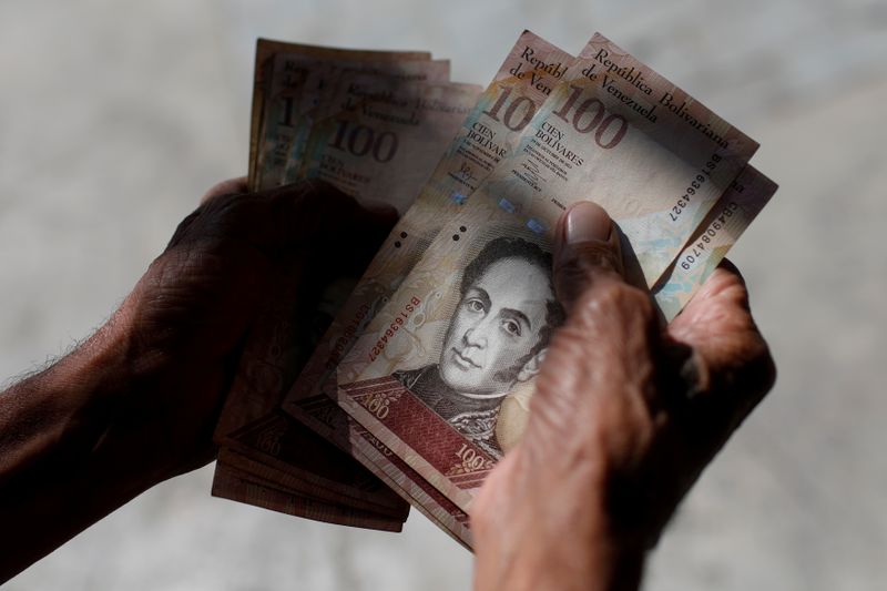 &copy; Reuters. FILE PHOTO: A man counts Venezuelan bolivar notes in downtown Caracas