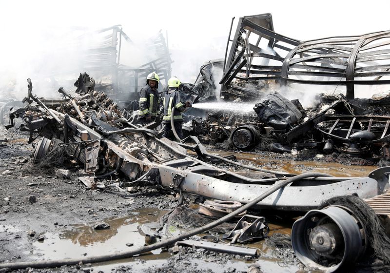 © Reuters. Afghan firefighters spray water on a truck after an overnight fire, on the outskirts of Kabul