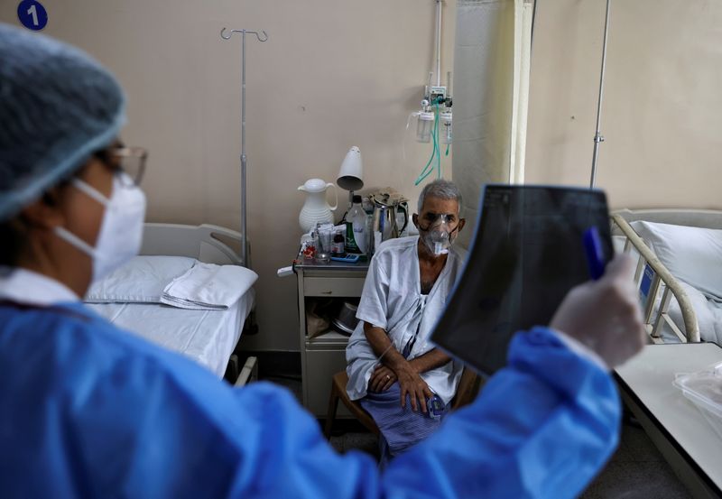 &copy; Reuters. A doctor checks an X-ray of a patient suffering from the coronavirus disease (COVID-19) inside a COVID-19 ward of a hospital in New Delhi