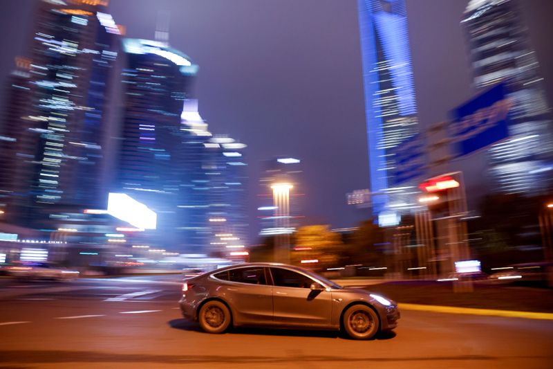 © Reuters. FILE PHOTO: A Tesla electric car drives past a crossing in Shanghai