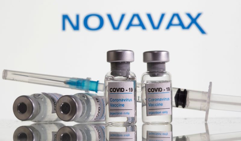 &copy; Reuters. FILE PHOTO: FILE PHOTO: Vials labelled &quot;COVID-19 Coronavirus Vaccine&quot; and sryinge are seen in front of displayed Novavax logo in this illustration