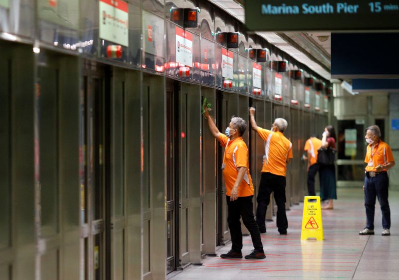 &copy; Reuters. FILE PHOTO: Workers wipe down doors at a train station during the coronavirus disease (COVID-19) outbreak in Singapore