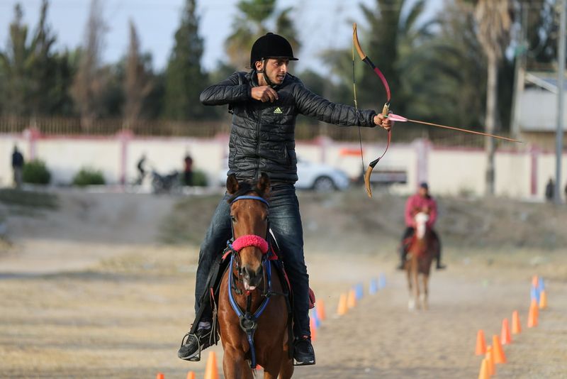 &copy; Reuters. شاب فلسطيني يصوب السهم على هدف من على ظهر حصان أثناء تدريب في الزوايدة بوسط قطاع غزة يوم 28 ابريل نيسان 2021. تصوير: إبراهيم أبو مصطفى - رويترز.